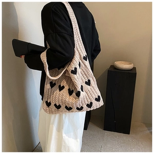 Détail du sac cabas en tricot à motif cœur avec texture épaisse et large bandoulière