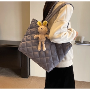 Detailed shot of grey-purple quilted nylon tote bag featuring a cute bunny plush charm