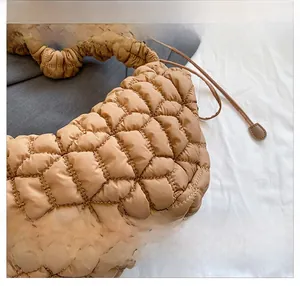 Detail showing the quilted bubble texture and brown nylon fabric of the shoulder bag