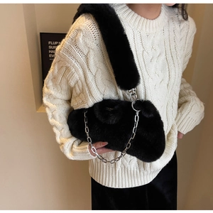 Détail d'un sac à bandoulière en fausse fourrure noire avec chaîne argentée chic