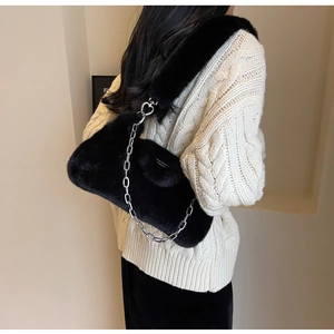 Détail du sac bandoulière en fausse fourrure noire avec fermoir cœur et chaîne argentée