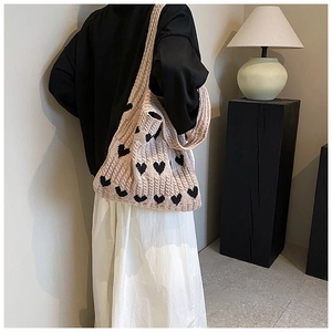 Gros plan du sac cabas en tricot avec motifs de cœurs noirs et texture épaisse