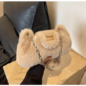 Détail du sac à main en fausse fourrure beige avec chaîne argentée et étiquette cuir