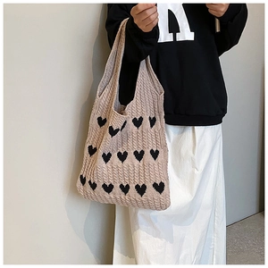 Gros plan du motif de cœur en tricot et texture en coton de ce sac cabas rose