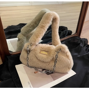 Gros plan sur le sac en fausse fourrure avec chaîne argentée et écusson en cuir logo