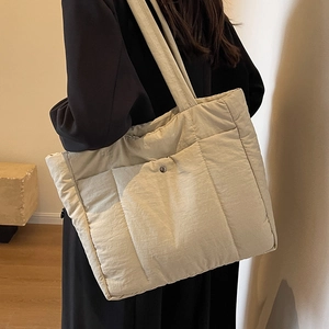 Quilted beige nylon tote bag with large capacity for commuting, shown on shoulder