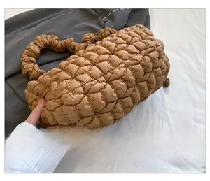 Detail of khaki quilted nylon dumpling bag showing bottom stitching and puffed fabric texture