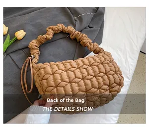 Close-up of caramel quilted dumpling bag with ruched handle and side drawstring detail