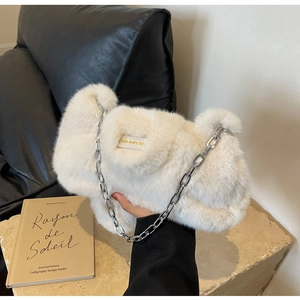 Détail d'un sac en fausse fourrure blanche avec chaîne argentée et broderie love