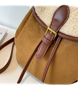 Detail of suede and faux shearling patchwork backpack with golden buckle accent