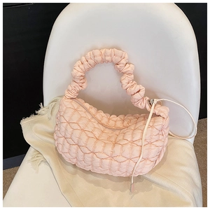 Detail of light pink quilted dumpling bag showing pleated texture and puffed fabric