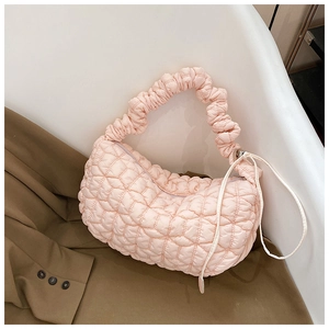 Detailed texture of pink quilted puffy dumpling bag beside a stylish brown blazer