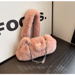 Détail d'un sac à main en fausse fourrure rose avec bandoulière chaîne argentée