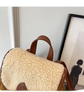 Detail of plush fleece flap and durable brown faux leather handle on travel backpack