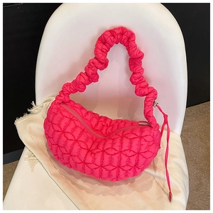 Close-up of bright pink quilted nylon dumpling bag with pleated shoulder strap detail