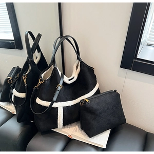 Detail of black matte tote and clutch set with decorative white shearling trim and strap