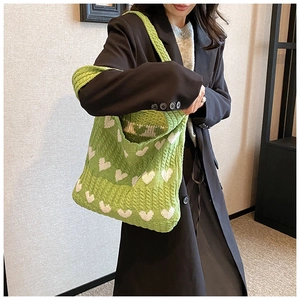 Détail du sac cabas en tricot vert avec motifs de cœurs blancs et bandoulière large