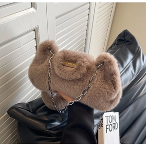 Détail du sac à bandoulière en fausse fourrure marron avec plaque en métal dorée
