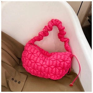 Detailed close-up of neon pink cloud bag with quilted bubble texture on a white chair