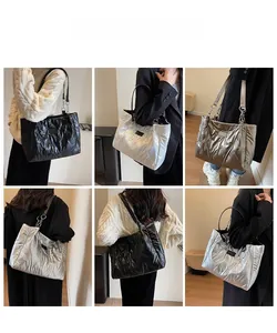Quilted down tote bag with chain strap shown in black, silver and champagne colors