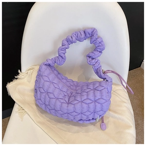 Close-up of lilac quilted nylon dumpling bag with decorative ruffled handles and fine stitching