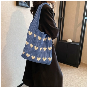 Détail du sac cabas en tricot bleu avec motif jacquard cœur blanc sur l'épaule