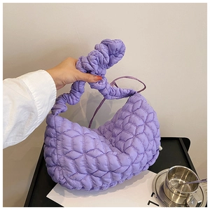 Detail of purple quilted cloud bag featuring soft fabric and unique knotted handle design