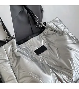Detailed view of silver quilted tote bag featuring metallic texture and black leather logo