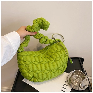 Detail of light green pleated nylon shoulder bag with cloud-like quilted texture