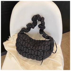 Detail shot of black quilted nylon dumpling bag with a scrunchie strap and drawstring