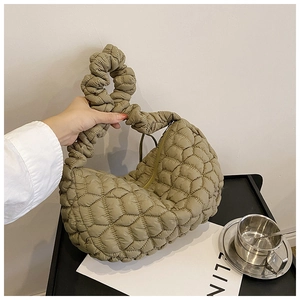 Macro detail of puffy quilted dumpling bag in olive green with zipper and soft texture