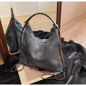Detail of vintage grey suede hobo bag with leather handle and silver metal chain strap