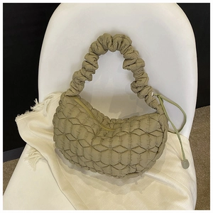 Detailed view of khaki quilted dumpling bag featuring ruched handles and geometric stitching