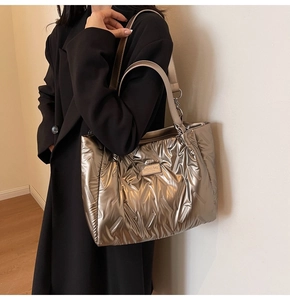 Close-up of quilted metallic tote bag with double straps and fashion brand plate