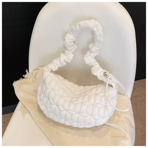 Detail of white quilted nylon dumpling bag with textured puffy surface and ruched strap