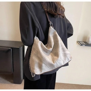 Detail of grey marble texture leather hobo bag with thick silver chain and brown strap