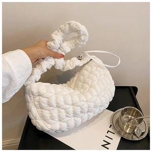 Close-up of white quilted bubble texture and zipper detail on a soft nylon cloud bag