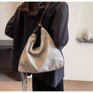 Detail showing high-capacity grey hobo bag with vintage texture and chain strap