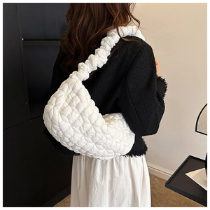 Detail of white quilted nylon dumpling bag featuring 3D bubble texture and puffy strap