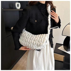 Detail of white quilted nylon dumpling bag with pleated wide shoulder strap design