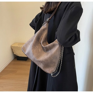Detail of grey-brown frosted hobo bag with metal chain strap for autumn winter style