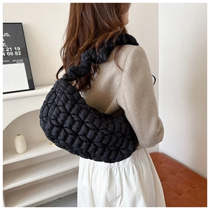 Detail of black quilted cloud bag showing nylon bubble texture and ruched shoulder strap