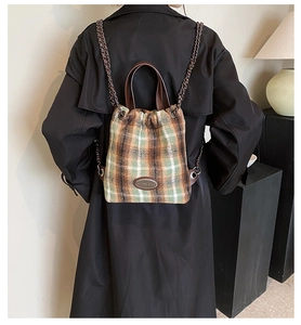 Detail-Rückansicht einer Frau mit kariertem Tweed-Rucksack mit Kordelzug und Kettenriemen