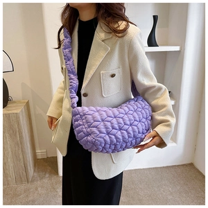 Detail of purple quilted nylon crossbody bag showing the stylish puffy texture on a model