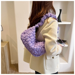 Detail of purple quilted nylon dumpling bag with pleated shoulder strap and soft texture