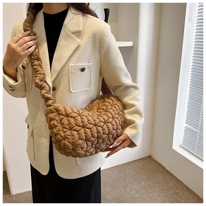 Detail of caramel quilted nylon crescent bag with a ruched scrunchie shoulder strap