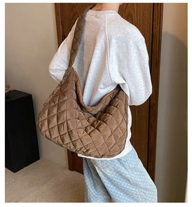 Macro detail of coffee brown quilted nylon bucket bag with diamond lattice stitching