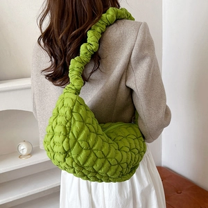 Grass green quilted nylon dumpling bag with wide ruffled strap and crescent shape style