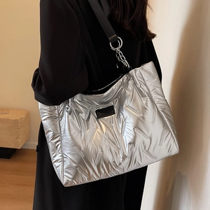 Metallic silver quilted tote bag with black leather straps and metal chain link detail