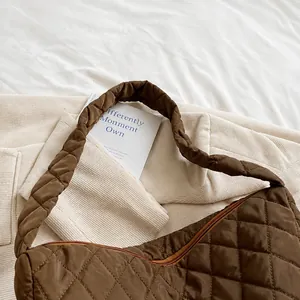 Gros plan détaillé de la poignée rembourrée confortable sur un sac seau matelassé marron